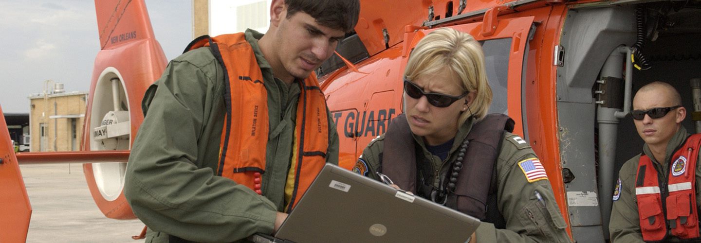 Coast guard officers work over a tablet