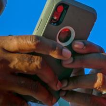 Close up of a smartphone in the hands of a public safety official