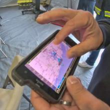 An officers holds a FirstNet device used to track severe weather events and share real time data with responders.