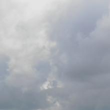 A cell tower in front of a cloudy sky